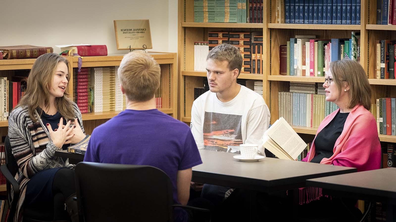 Small group of students having discussion with instructor in Catholic Studies classroom